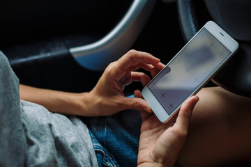 woman looking something in the phone sitting in the car on a summer day