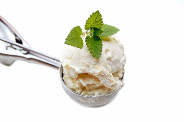 A steel ice cream scoop filled with vanilla ice cream