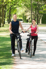 Happy Couple Standing With Bicycles