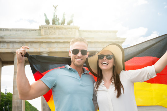 Smiling Couple Holding German Flag