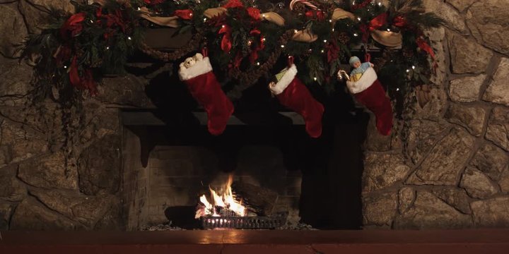 Three stocking full of gifts hanging from a fireplace mantel