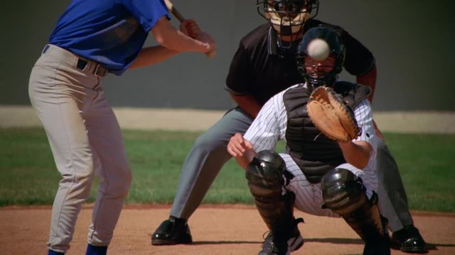 Left-handed batter swinging at ball and missing, slow motion