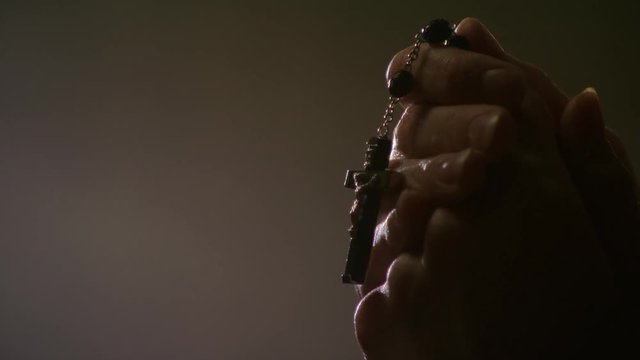 Close-up of woman's hands holding rosary