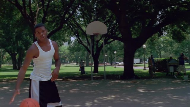 Teenage boys passing the basketball around an outdoor court