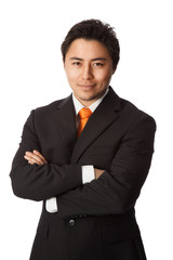 A tough businessman wearing a black suit with an orange tie, standing with his arms crossed staring at camera. White background.
