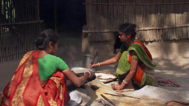 Women cooking outdoors on an earthen stove in Calcutta