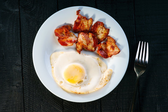 Fried egg with bacon and fork