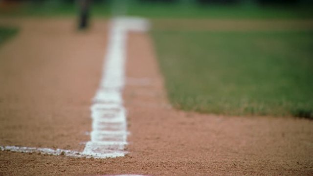 Slow-motion close-up of base runner's cleats rounding third base