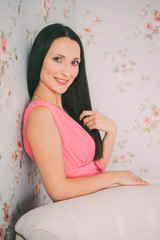 Portrait of cute brunette girl in pink dress, looking into the camera. Pastel shades tone - 114753017