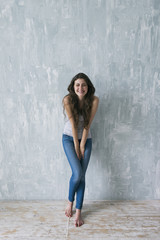 Studio shot of smiling shy brunette with squinting eyes