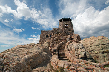 Harney Peak Fire Lookout watchtower with cumulus clouds overhead in Custer State Park in the Black...