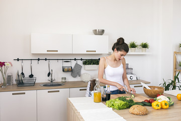 Brunette cutting vegetables for salad