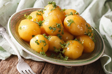 Glazed new potatoes with parsley close-up on the table. Horizontal
