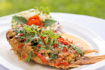 Deep fried red tilapia topped with sweet and sour sauce on top,