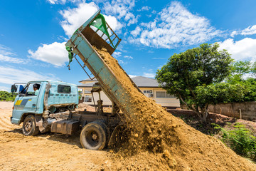 Dump truck unloading soil at construction site
