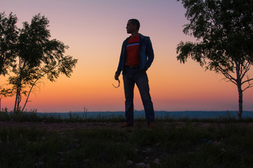 Sunrise. The man sits on the mountain at sunrise. Восход солнца. Мужчина сидит на горе на восходе солнца.


