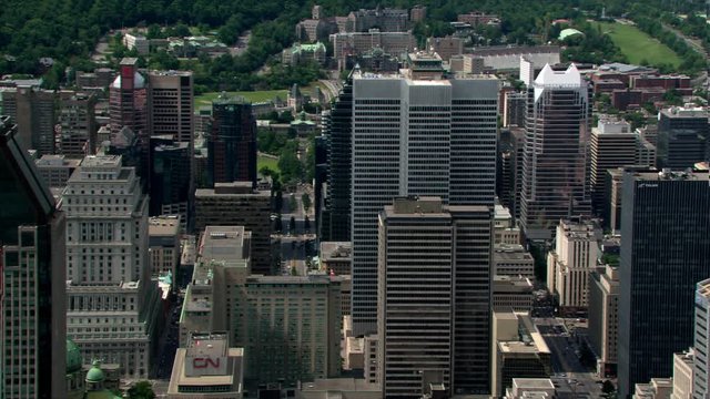 Flying past skyscrapers toward green space in Montreal, Quebec. Shot in 2003.