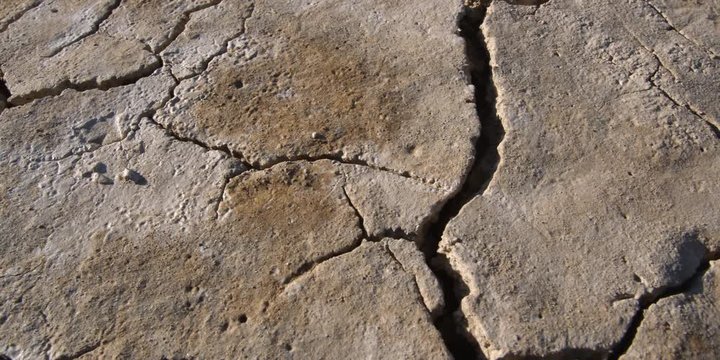 Extreme close-up and right pan of deep cracks in alkali earth