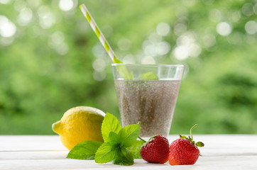 Chia seeds drink with water in transparent glass with lemon, min