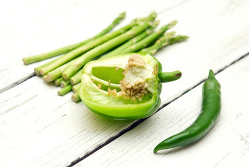 Green peppers and asparagus on a wooden background