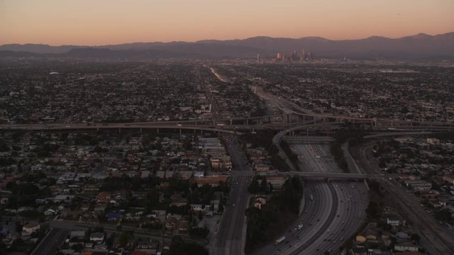 Flying over Los Angeles freeways and interchanges toward downtown in evening light. Shot in 2010.