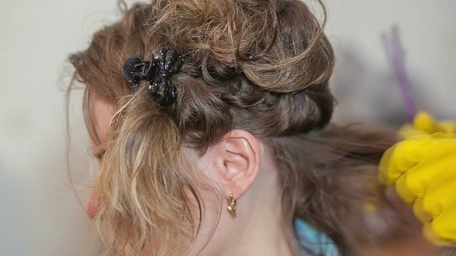 Two girls make keratin straightening hair at home.