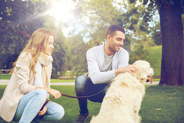 happy couple with labrador dog walking in city