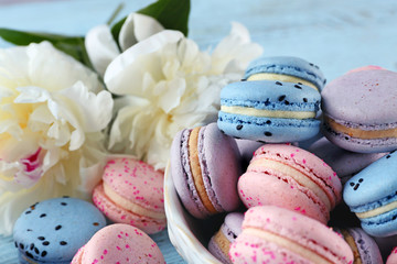 Bowl with macaroons and peonies, closeup