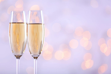 Two champagne glasses on light background