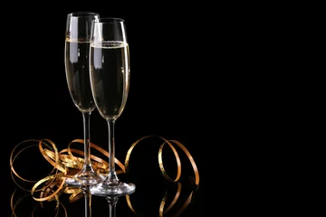 Foto op Aluminium Two champagne glasses with golden ribbon on black background © Africa Studio