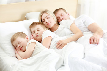 Lovely sleeping family in bed