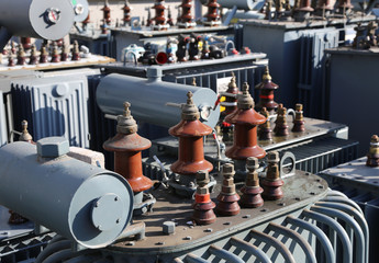 many old large electric voltage transformers in the dump of the