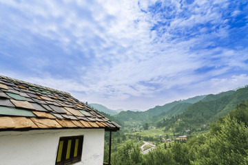 Idyllic landscape of the Janjehli valley and multicolor roofed h