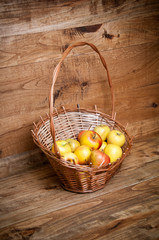 Basket with apples on wooden background