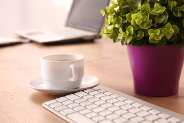 Office table with blank notepad and laptop
