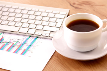 Office table with blank notepad and laptop