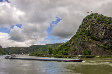 Fototapeta na wymiar Frachtschiff umfährt den Loreleyfelsen am Rhein