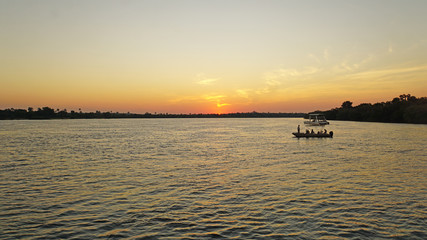Fototapeta na wymiar Der Sambesi in Sambia/Sonnenuntergang auf dem Sambesi in Sambia, Boote in der Abendsonne 