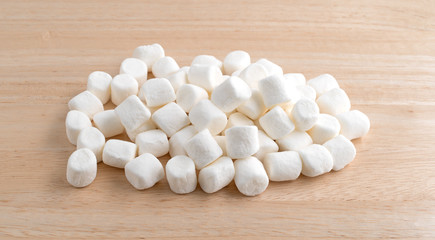 Fototapeta na wymiar Small marshmallows on a wood cutting board