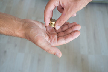 Man giving coins to another person