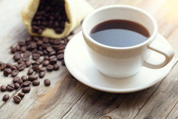 Closeup coffee cup and beans on wooden table