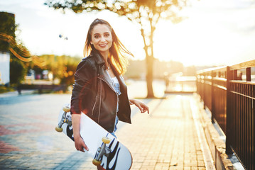 Girl walks in the park to skateboard