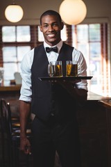 Bartender holding serving tray with glasses of beer
