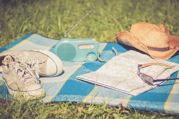 Sneakers, Straßenkarte und Strohhut auf Picknickdecke, retro