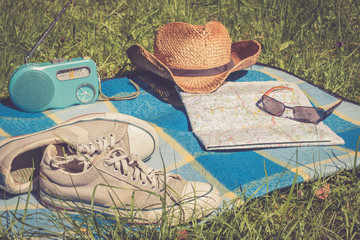 Sneakers, Straßenkarte und Strohhut auf Picknickdecke, retro