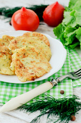 
vegetable breakfast or lunch , zucchini pancakes with dill , fresh tomatoes , lettuce and herbs on a wooden background