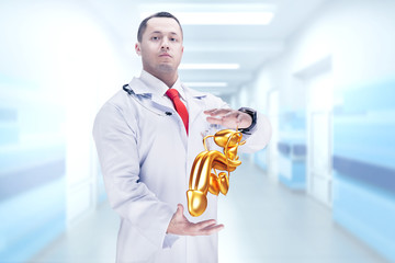 Doctor with stethoscope and golden penis on the hands in a hospital. High resolution.