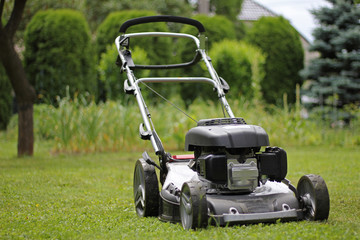 Lawn mower in the garden after mowing grass, powerful petrol lawn mower