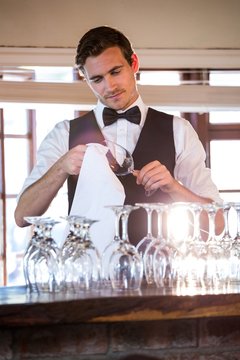 Bartender cleaning wineglass 