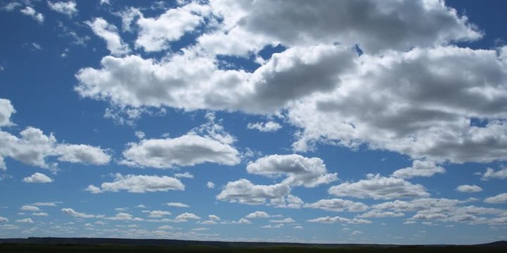 Time-lapse white puffy clouds drifting across blue sky